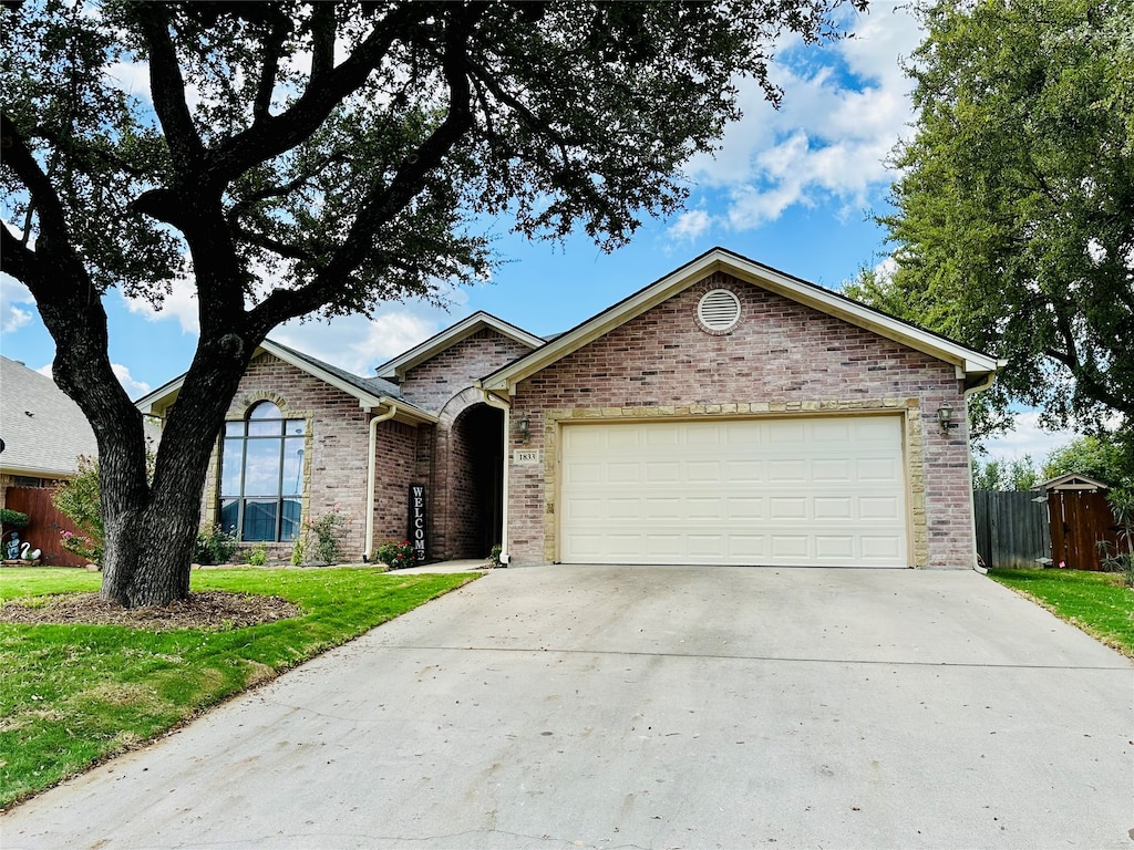 ranch-style home with a front lawn and a garage