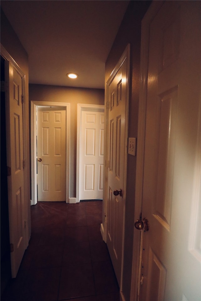 hall featuring dark tile patterned flooring