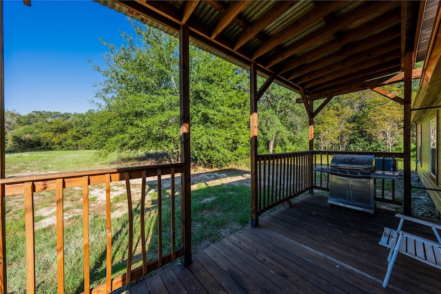 wooden terrace featuring a yard and a grill