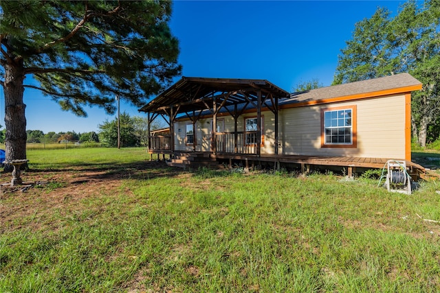 back of house with a wooden deck and a yard