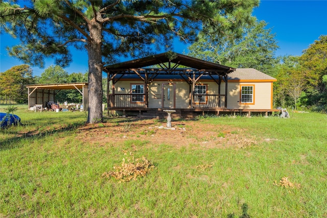 rear view of house with a gazebo, a deck, and a yard