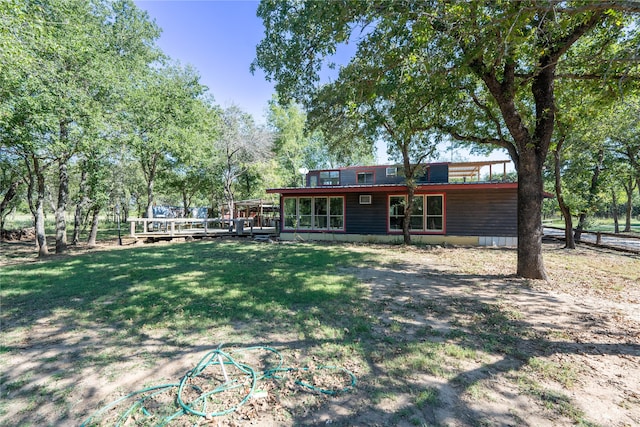 exterior space with a sunroom, a yard, and a deck