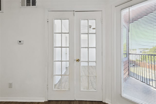 doorway with french doors, dark hardwood / wood-style floors, and a healthy amount of sunlight