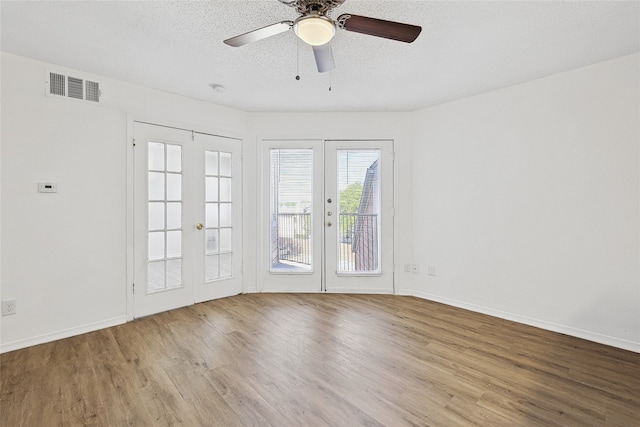 spare room featuring light wood-type flooring, a textured ceiling, ceiling fan, and french doors