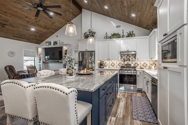 kitchen with pendant lighting, stainless steel appliances, high vaulted ceiling, and white cabinetry