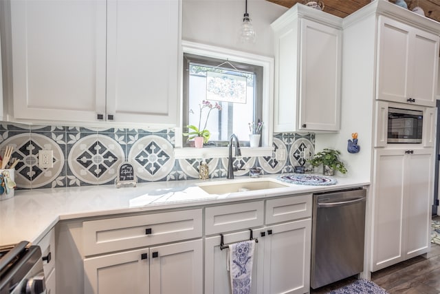 kitchen with white cabinets, sink, decorative light fixtures, dark wood-type flooring, and stainless steel appliances