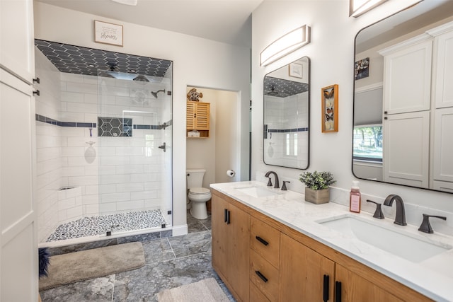 bathroom featuring a tile shower, vanity, and toilet