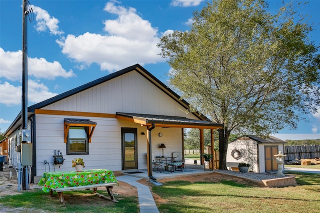 view of front of property featuring a shed, a patio, and a front yard