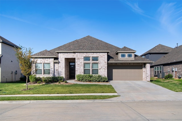 view of front of home featuring a front lawn, cooling unit, and a garage