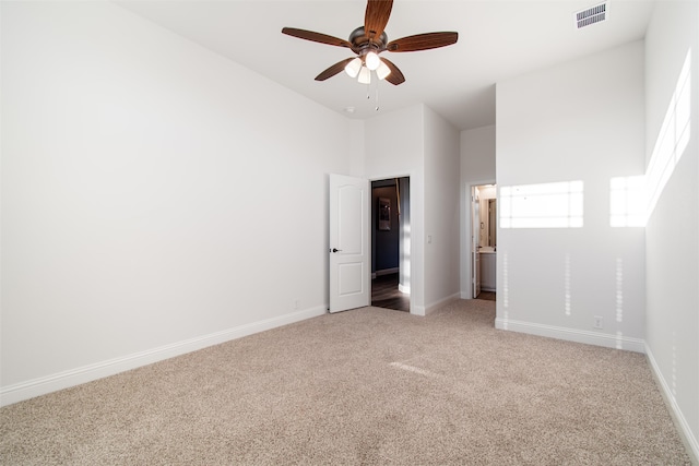 unfurnished bedroom with carpet floors, a high ceiling, and ceiling fan