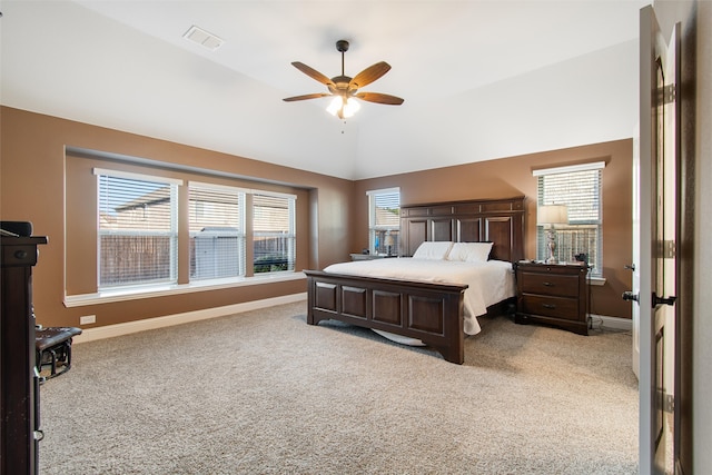 bedroom with multiple windows, ceiling fan, vaulted ceiling, and light colored carpet