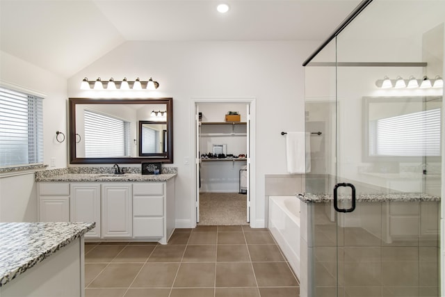 bathroom featuring tile patterned flooring, plus walk in shower, vaulted ceiling, and vanity