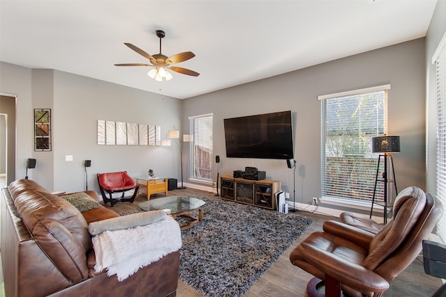 living room with wood-type flooring, ceiling fan, and a healthy amount of sunlight