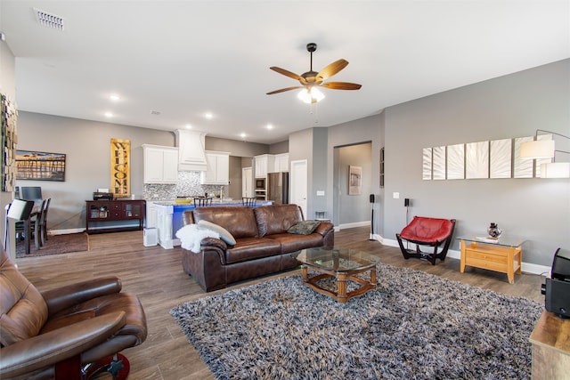 living room with ceiling fan and dark hardwood / wood-style flooring