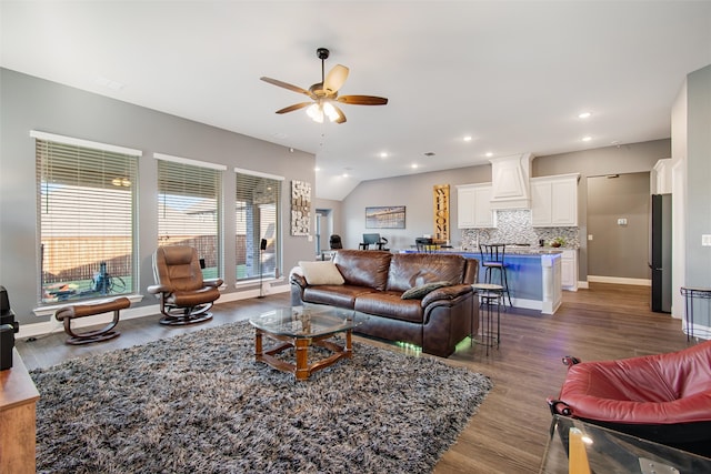 living room with dark hardwood / wood-style floors, vaulted ceiling, and ceiling fan