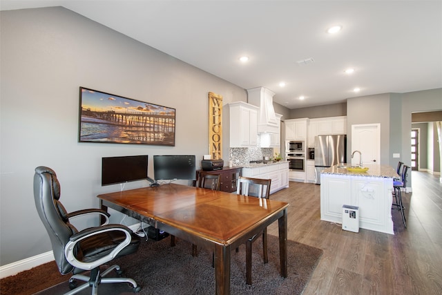 office space featuring vaulted ceiling, sink, and dark hardwood / wood-style flooring