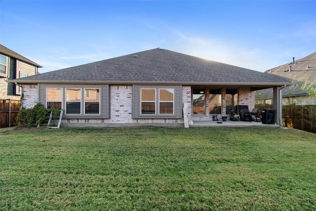 rear view of house with a yard and a patio area