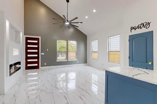 unfurnished living room featuring high vaulted ceiling and ceiling fan