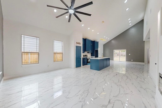 unfurnished living room featuring high vaulted ceiling, a wealth of natural light, and ceiling fan