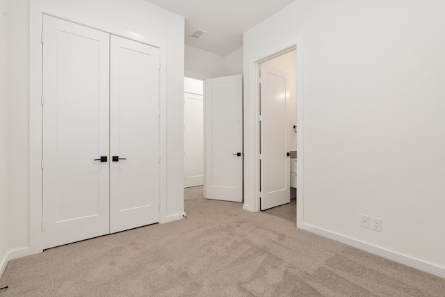 unfurnished bedroom with light carpet and a closet