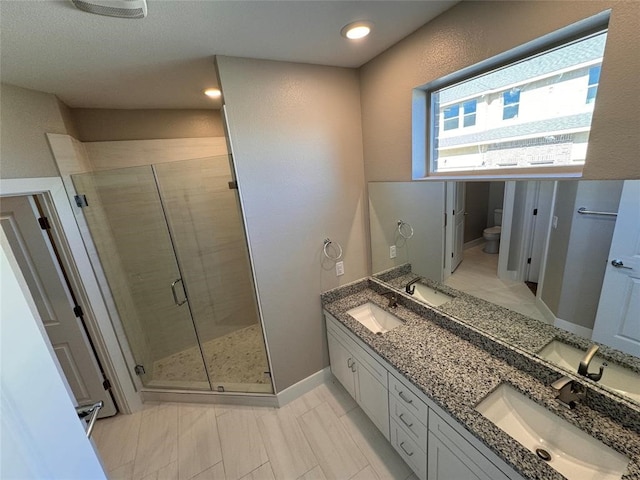 bathroom with vanity, toilet, and a shower with door