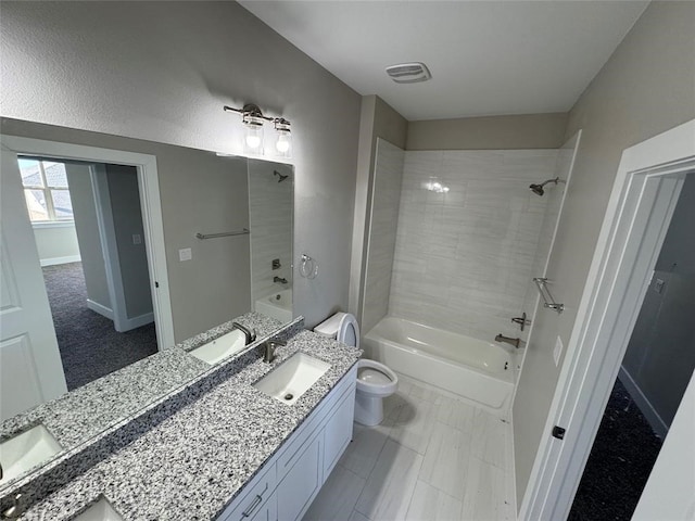 full bathroom with tiled shower / bath combo, tile patterned flooring, vanity, and toilet