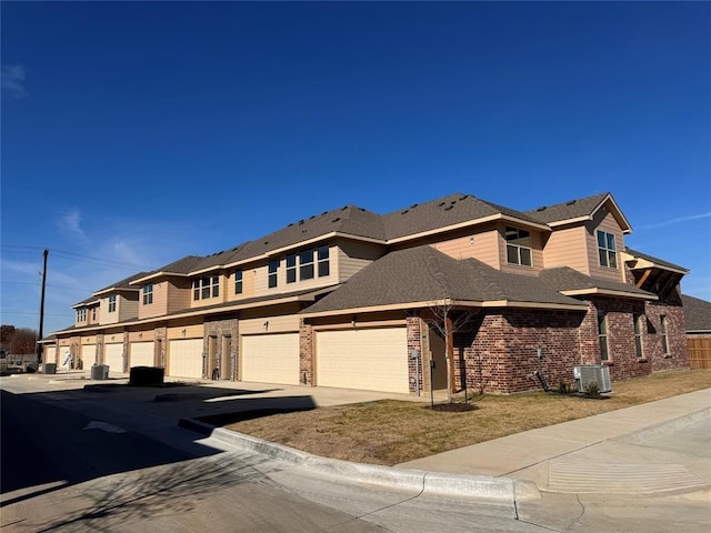 view of front of property featuring cooling unit, a garage, and a front yard