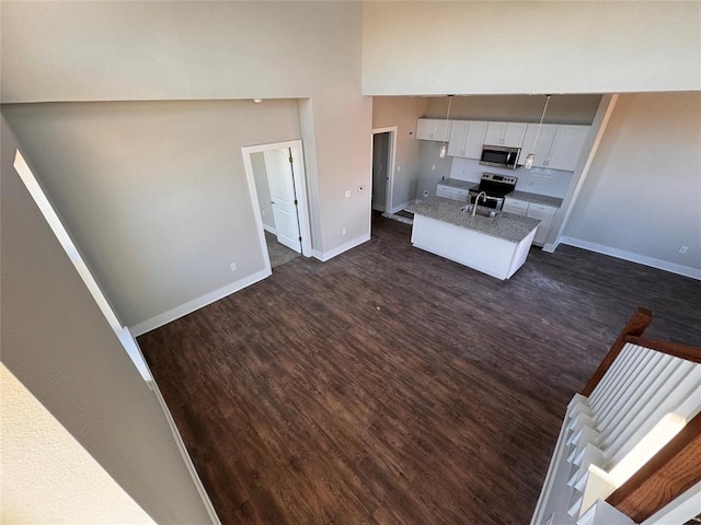 kitchen featuring stainless steel appliances, white cabinetry, dark wood-type flooring, and sink