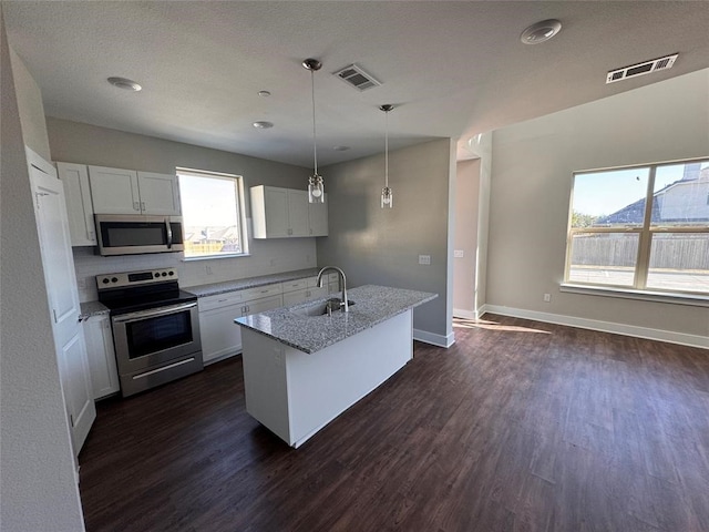 kitchen featuring stainless steel appliances, white cabinetry, a wealth of natural light, and sink