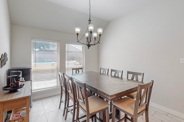 tiled dining room featuring a notable chandelier and vaulted ceiling