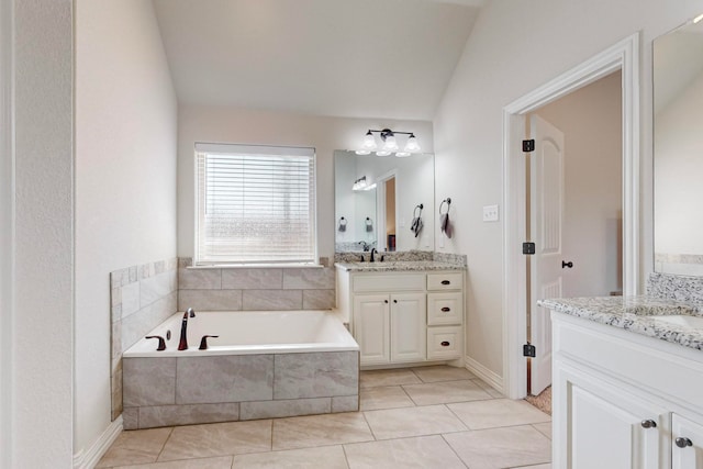 bathroom featuring vanity, tiled bath, tile patterned flooring, and lofted ceiling