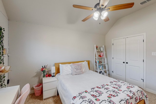 bedroom featuring ceiling fan, a closet, light carpet, and vaulted ceiling