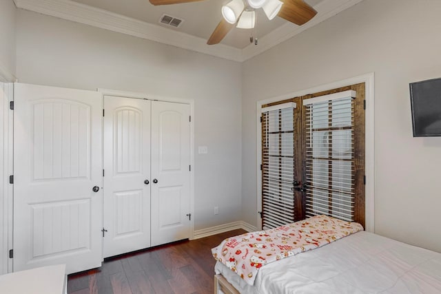 bedroom featuring ceiling fan, a closet, dark hardwood / wood-style floors, and crown molding