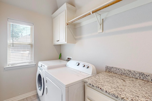 laundry room featuring light tile patterned flooring, washer and dryer, and cabinets