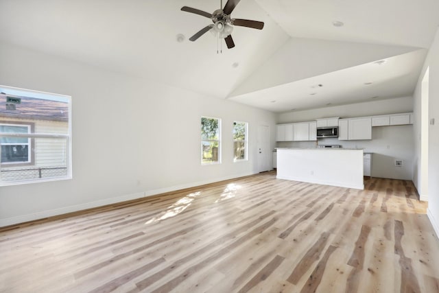 unfurnished living room with light wood finished floors, ceiling fan, baseboards, and high vaulted ceiling