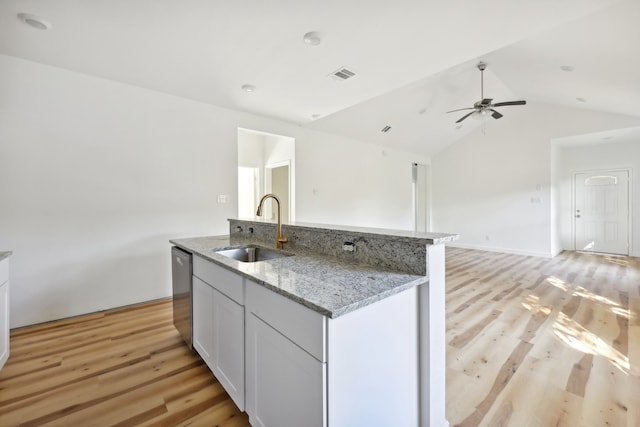 kitchen with dishwasher, light wood finished floors, a sink, and visible vents