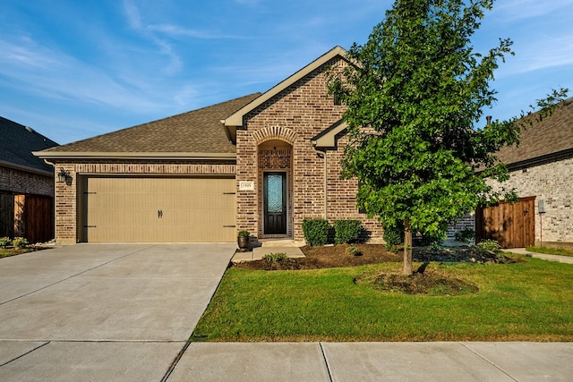 view of front of home with a front yard and a garage