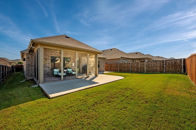 back of property with a lawn and a patio