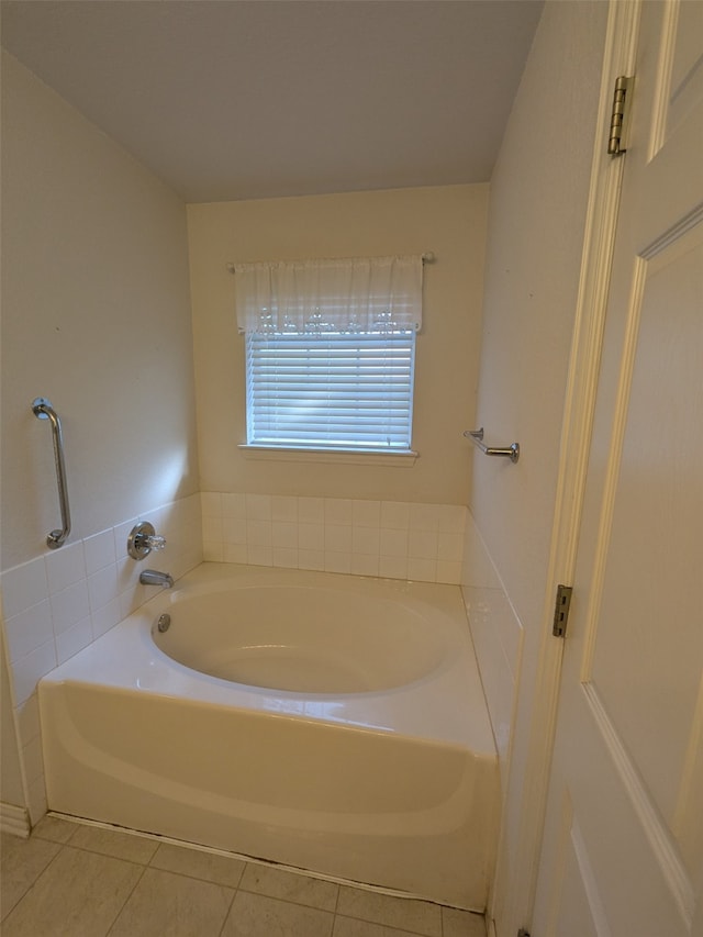 bathroom with a tub to relax in and tile patterned flooring