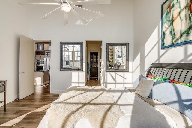 2600 W 7th St Unit 2746, Fort Worth, TX 76107 - bedroom featuring wood finished floors, baseboards, a high ceiling, and freestanding refrigerator