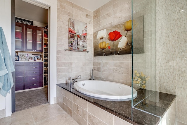 bathroom featuring tile walls, shower with separate bathtub, and tile patterned floors