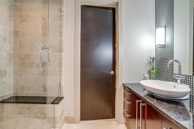 bathroom featuring walk in shower, vanity, backsplash, and tile patterned flooring