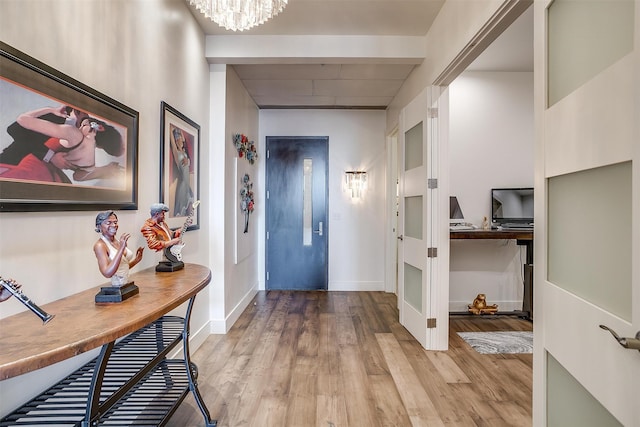 entryway with light hardwood / wood-style floors and a chandelier