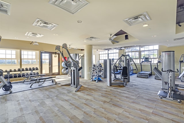 gym with light carpet, ceiling fan, and plenty of natural light