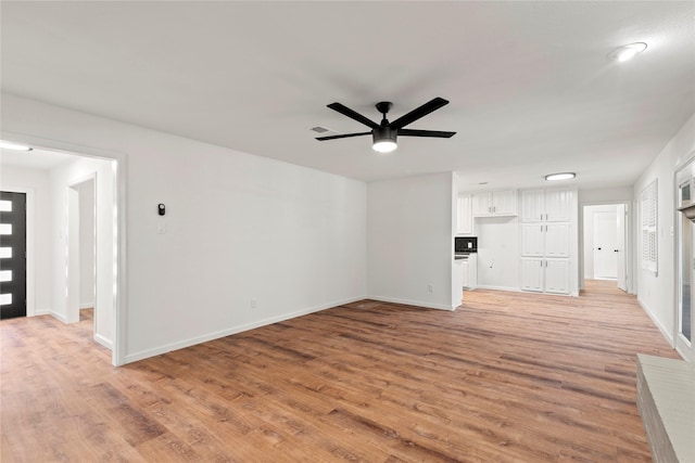 unfurnished living room featuring light wood-style flooring, visible vents, and baseboards