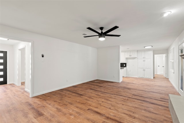 unfurnished living room featuring ceiling fan and light hardwood / wood-style flooring