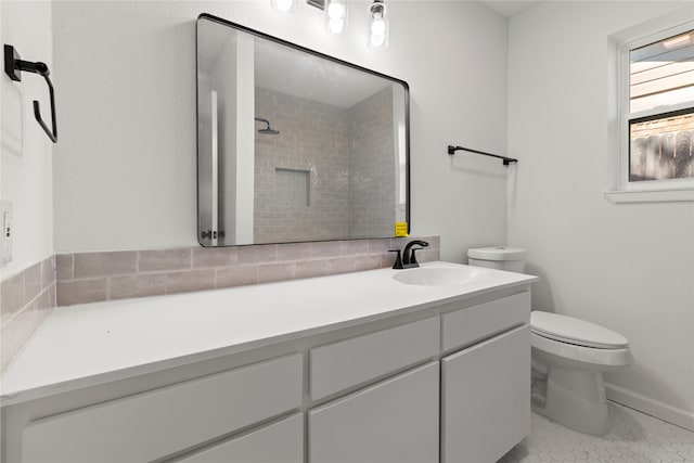 bathroom featuring a tile shower, vanity, tile patterned flooring, and toilet