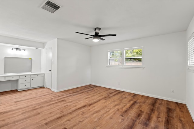 unfurnished bedroom with light wood-style floors, visible vents, baseboards, and built in study area