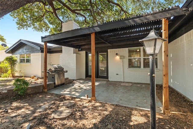 rear view of house featuring brick siding, a chimney, a patio area, and a pergola