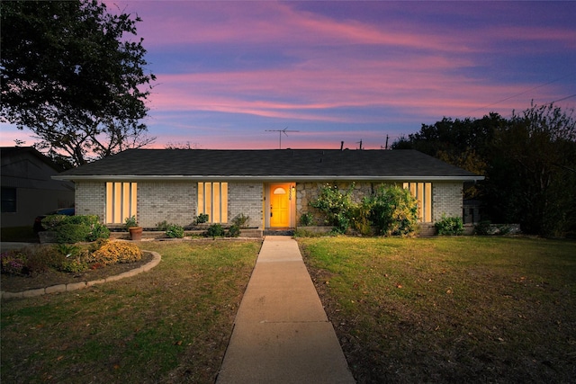 ranch-style home featuring a lawn